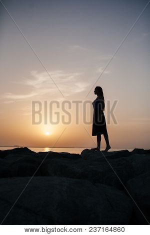 Beautiful Girl On A Sunset Background On A Sandy Beach. Woman.
