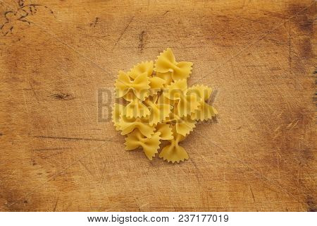 Farfalle Raw Farfallini Background With Pasta On Wooden Table Background. A View From The Top, A Clo