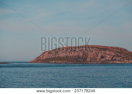 Norway. Small Island Outside Vardo With A Lighthouse To Guide Ships When It Is Dark