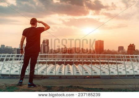 Backwards Guy Looking At Sunrise Skyline Over A Seaside City