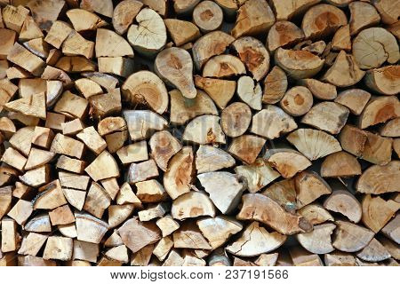 Material For Heating The House. Preparation Of Firewood For The Winter. Background Of Firewood