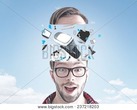 Portrait Of An Astonished Young Man Wearing Glasses And A Checkered Shirt. He Has Gadgets Emegring F