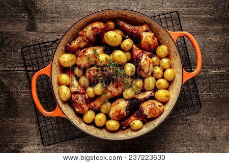 Oven Baked Chicken Drumsticks And New Baby Potatoes With Thyme In Pan, Ready To Serve.