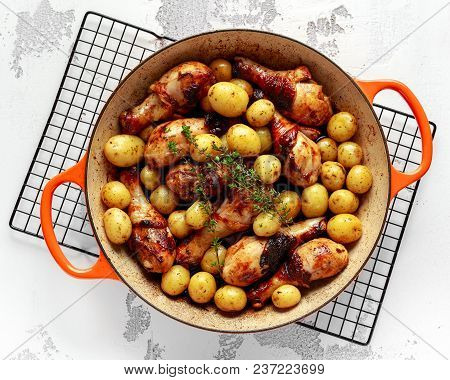 Oven Baked Chicken Drumsticks And New Baby Potatoes With Thyme In Pan, Ready To Serve.