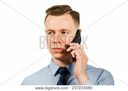 Close-up Portrait Of Young Businessman Dressed In Blue Shirt And Tie Talking On The Mobile Phone, Is