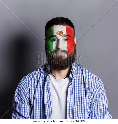 Face Of Young Bearded Man Painted With Flag Of Mexica. Football Or Soccer Team Fan, Sport Event, Fac