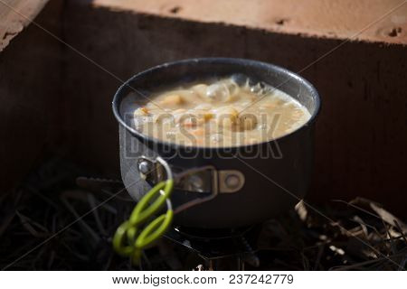 A Closeup Of A Boiling Pot On A Gas Primus Cooking Dinner For Hikers. Outdoors Kitchen.