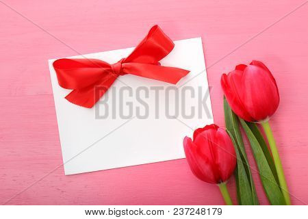 Tulips With Greeting Card On A Pink Background