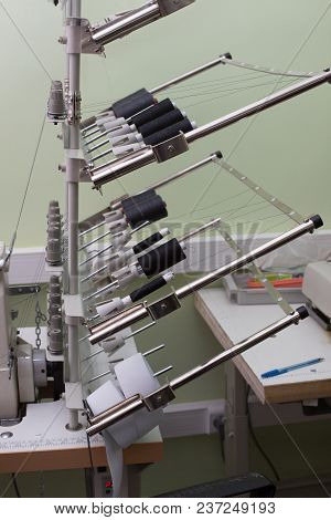 Professional Overlock Sewing Machine With Black Thread In Workshop. Equipment For Edging, Hemming Or