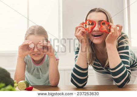 Beautiful Woman With Her Daughter Looks Happy While Cooking Salad Anf Having Fun In The Kitchen Over