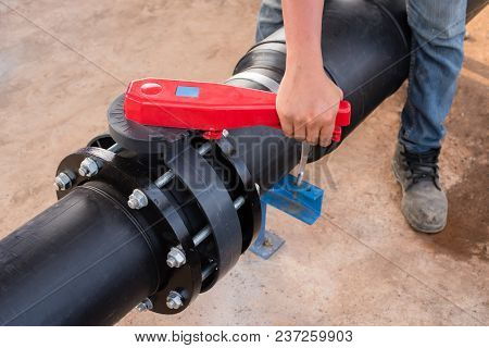 Plumber Hand Opening Butterfly Valve In Water Treatment Plant.