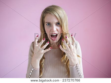 Portrait Of Furious Young Businesswoman With Red Nails And Wavy Fair Hair Screaming, Keeping Mouth W