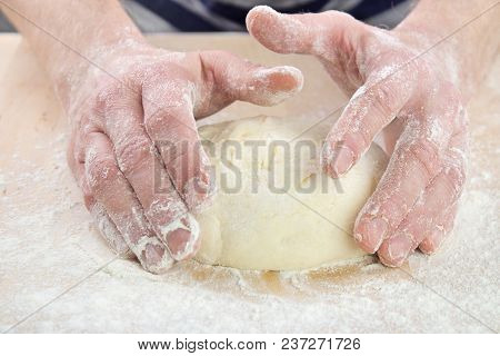 Pizza Baking , Starting To Shape Raised Dough Ball To Pizza Crust On Floured Wooden Board