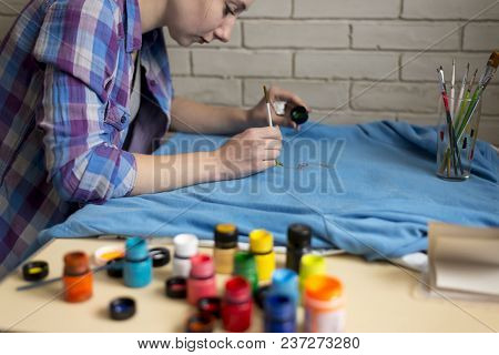 Photo Of A Girl Who Drawing Acrylic Paints On Blue Clothes