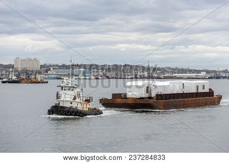 New Bedford, Massachusetts, Usa - April 17, 2018: Tug Sirius Towing Barge Load Of Modular Homes Acro