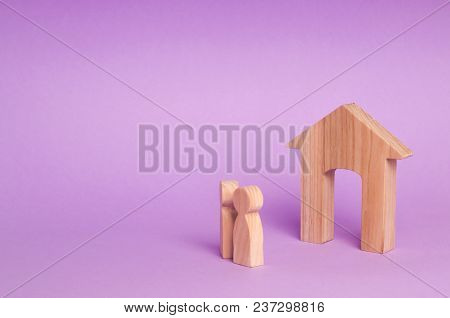 Two People Stand Near The House And Evaluate Its Qualities Before Buying. The Concept Of Buying And 