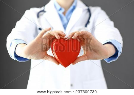 Female Doctor With Stethoscope Holding Heart In Her Arms. Healthcare And Cardiology Concept  In Medi