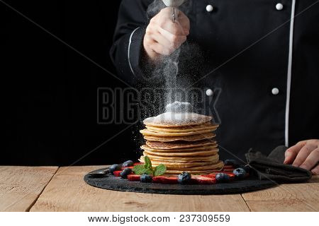 Serving Pancakes With Powdered Sugar And Berries. Chef Woman Hand. Beautiful Food Still Life. Slight