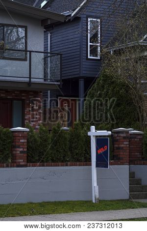 Sold Real Estate Sign Outside Of A Detached Residential House Exterior By The Sidewalk