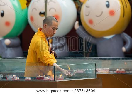 Chengdu, Sichuan Province, China - April 18, 2018 : Buddhist Monk Handling A Candle In Daci Buddhist
