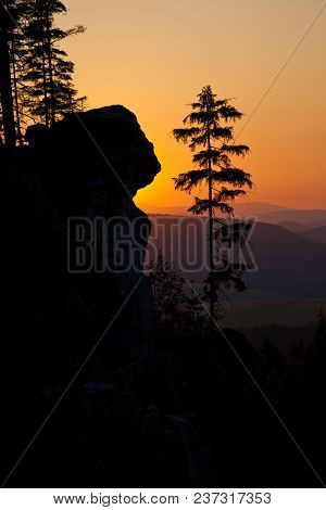 A Silhouetted Sandstone Cliff And Trees At Sunset On Ostas Hill In Northern Czech Republic