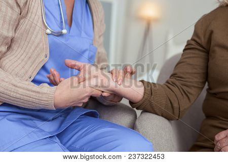 Frequent Pulse. Close Up Of Female Hand Holding Senior Female Hands While Calculating Puls