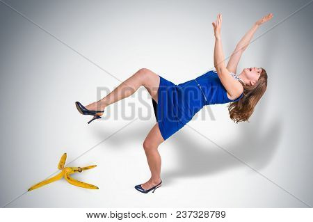 Business Woman Slipping And Falling From A Banana Peel - Business Risk Concept