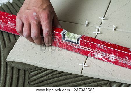 Ceramic Tiles And Tools For Tiler. Worker Hand Installing Floor Tiles. Home Improvement, Renovation 