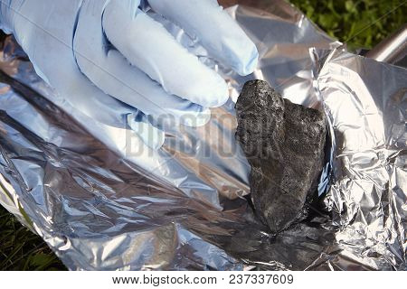 Man Packing Falling Meteorite To Aluminium Foil Outdoor