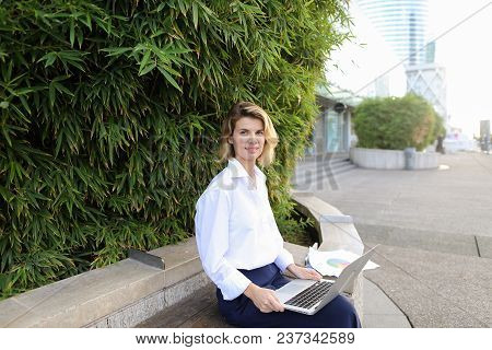 Businesswoman Working With Laptop And Papers In Open Air Near Green Plant. Concept Of Busines, Moder