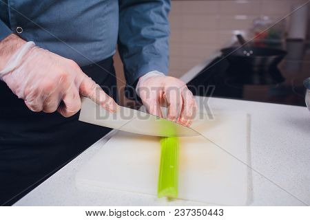 Housewife Cutting Celery To Cook In The Kitchen. Hands Slicing Celery With Knife On Chopping Wooden 