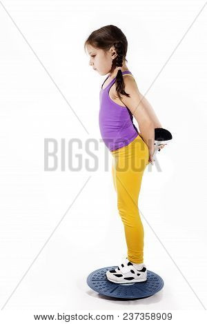 Little Caucasian Girl In On One Leg Position Staing On Balance Board. Photo On White Background