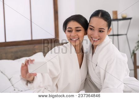 Beautiful Selfies. Delighted Positive Young Women Looking At The Smartphone Camera While Taking Phot