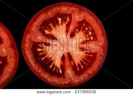 Red Tomato With Pulp And Seeds Isolated On Black Background