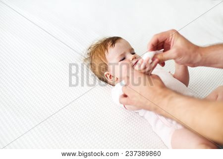 Six Month Baby On Bed Playing With Father. Happy Family Concept