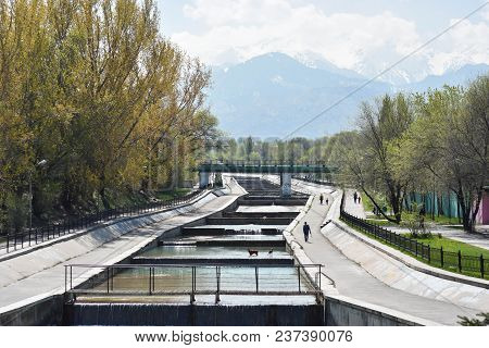 City River In The Spring Against The Background Of Mountains And Trees