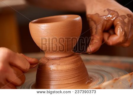 Close-up Hands Of A Male Potter In Plaid Shirt And Dirty Apron Who Molds A Vase From Clay, Selective