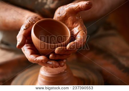 Close-up Hands Of A Male Potter In Plaid Shirt And Dirty Apron Who Molds A Vase From Clay, Selective