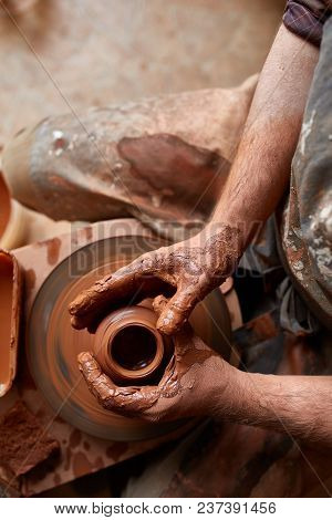 Close-up Hands Of A Male Potter In Plaid Shirt And Dirty Apron Who Molds A Vase From Clay, Selective