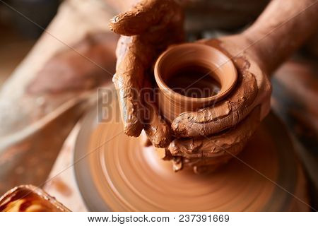 Close-up Hands Of A Male Potter In Plaid Shirt And Dirty Apron Who Molds A Vase From Clay, Selective
