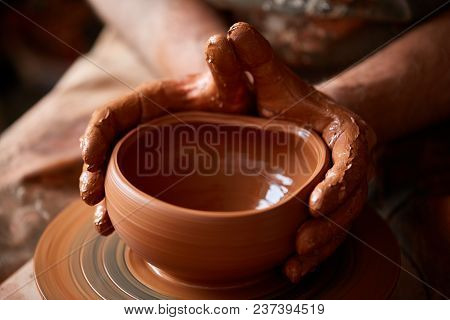 Close-up Hands Of A Male Potter In Plaid Shirt And Dirty Apron Who Molds A Vase From Clay, Selective