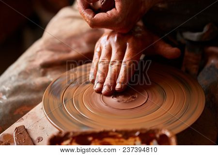 Close-up Hands Of A Male Potter In Plaid Shirt And Dirty Apron Who Molds A Vase From Clay, Selective