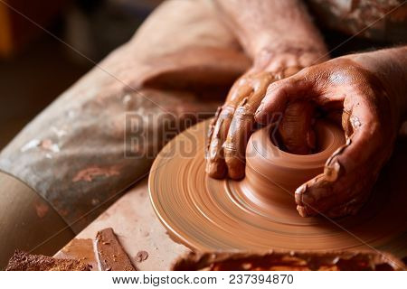 Close-up Hands Of A Male Potter In Plaid Shirt And Dirty Apron Who Molds A Vase From Clay, Selective