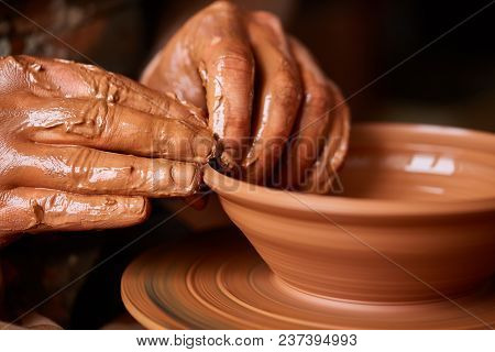 Close-up Hands Of A Male Potter In Plaid Shirt And Dirty Apron Who Molds A Vase From Clay, Selective