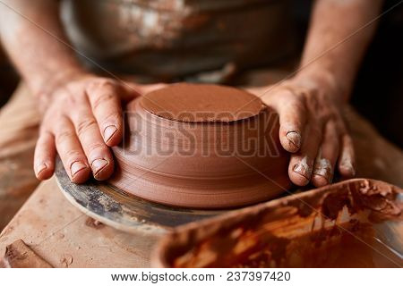 Close-up Hands Of A Male Potter In Plaid Shirt And Dirty Apron Who Molds A Vase From Clay, Selective