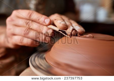 Close-up Hands Of A Male Potter In Plaid Shirt And Dirty Apron Who Molds A Vase From Clay, Selective