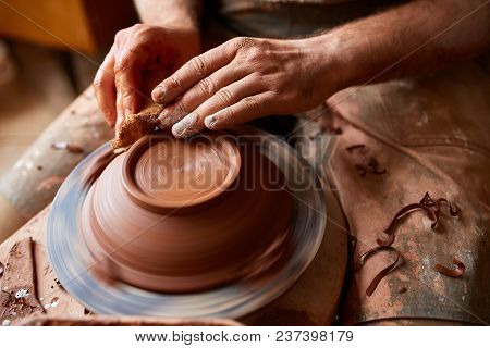 Close-up Hands Of A Male Potter In Plaid Shirt And Dirty Apron Who Molds A Vase From Clay, Selective