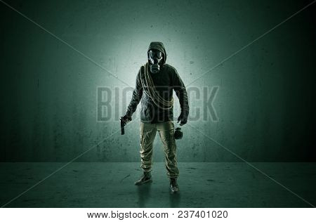 Bad agent in a dark room with arms on his hand and gas mask
