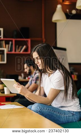 Beautiful Student Girl Working With Tablet Computer Sitting In Coworking Cafe Office