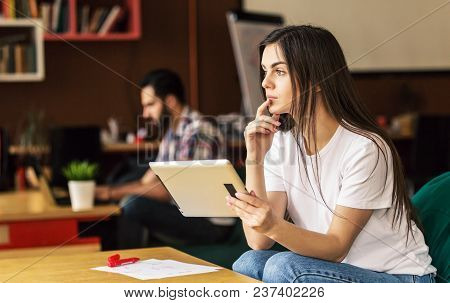 Girl Working With Tablet Computer Sitting In Coworking Cafe Office, Thinking Moment
